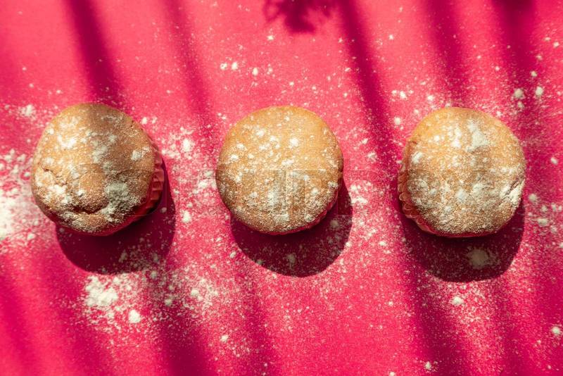 three muffins decorated with powdered sugar, bakery