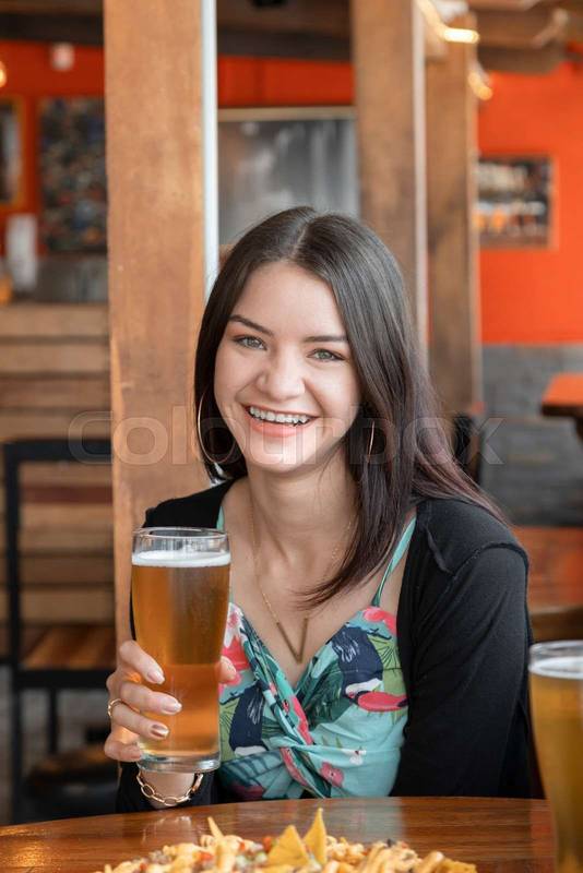 woman with long hair having fun in a restaurant with wooden furniture