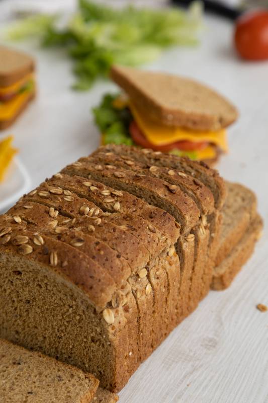 armed with whole wheat bread, cheese, lettuce and a plate with nachos on a table