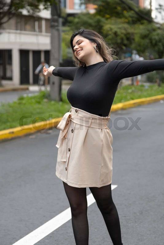young latin woman having fun on a city street