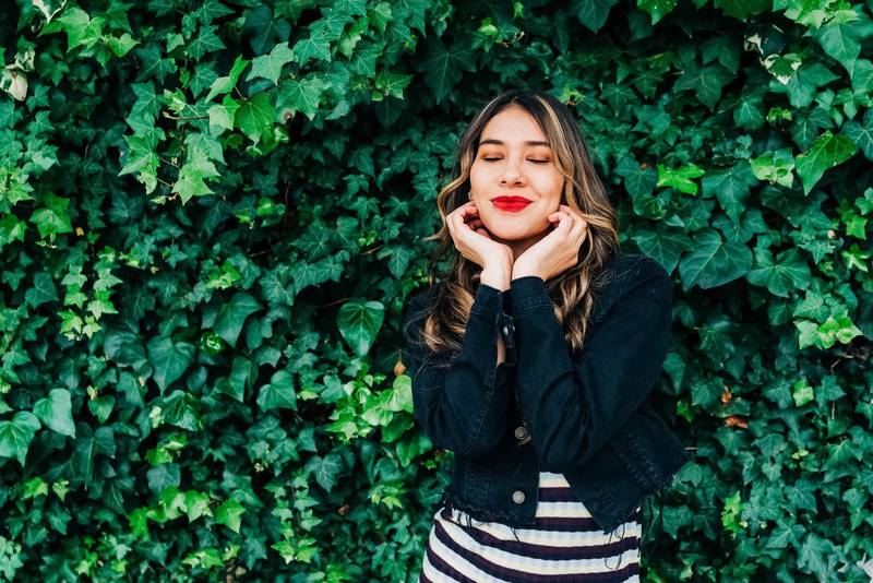 fresh leaf vine next to adorable latin young female model with long blonde hair