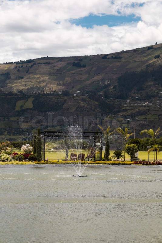Scenic landscaped garden with trimmed hedges, colorful plants, and a distant mountain view
