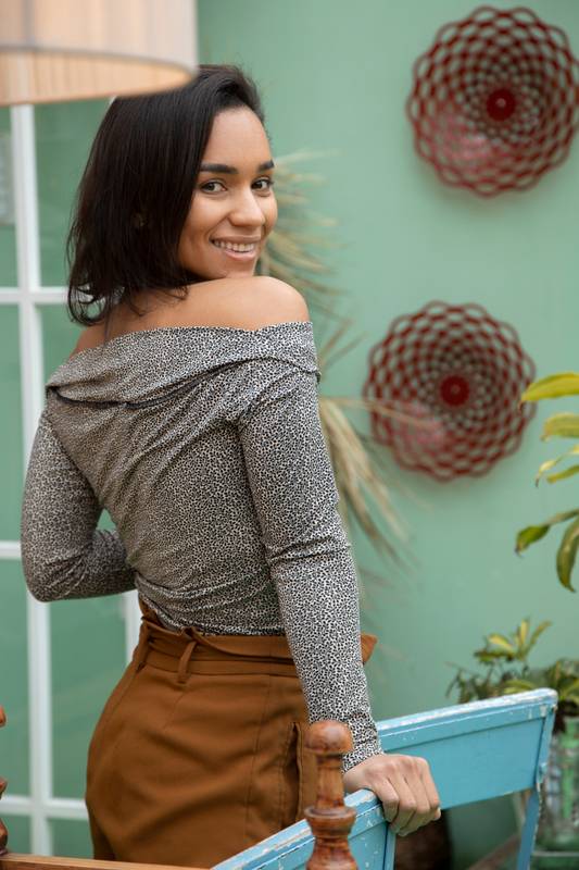 oman with short hair, standing showing her back and smiling