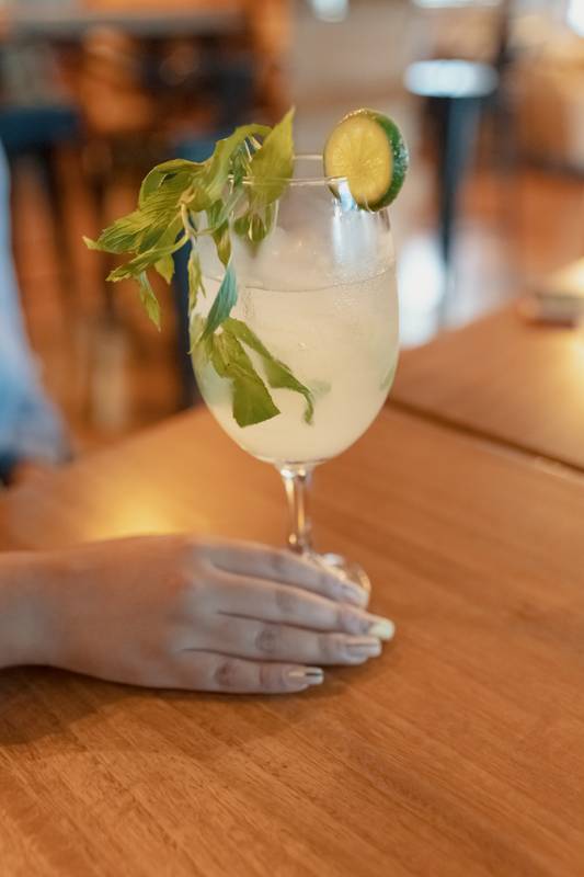 cocktail details with a hand holding it on a table