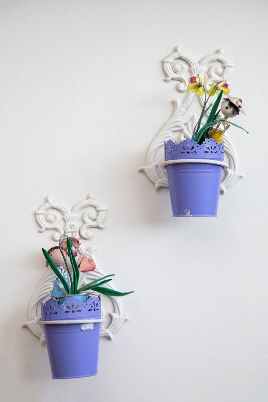 metal flower pots hanging on a white wall, colorful decorative