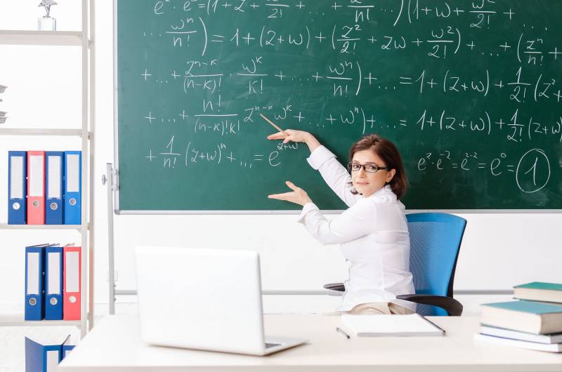 The teacher with young girl in the classroom | Colourbox