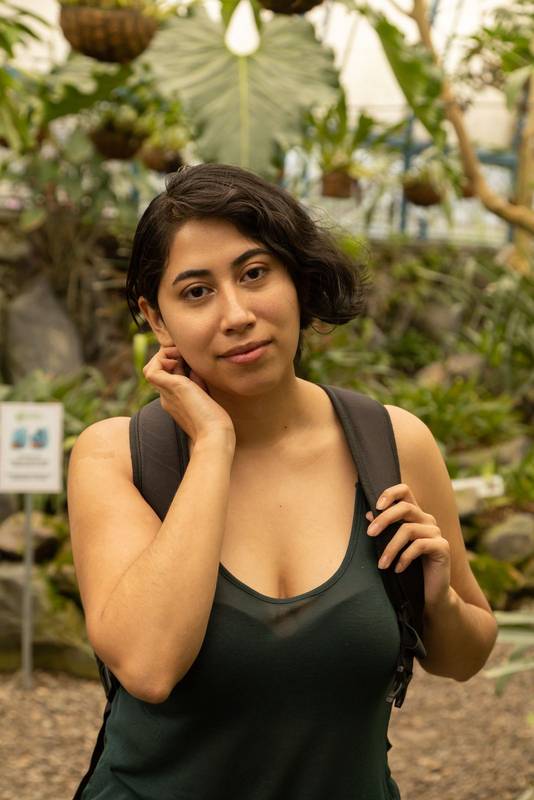 tourist on vacation inside a garden with nature, young latin woman
