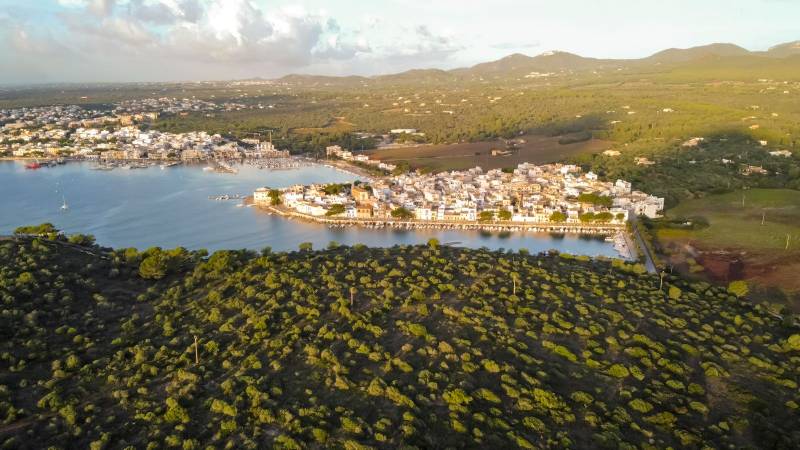 drone aerial view of the mediterranean sea at sunrise of small fishing port and marina, in portocolom,mallorca,balearic islands
