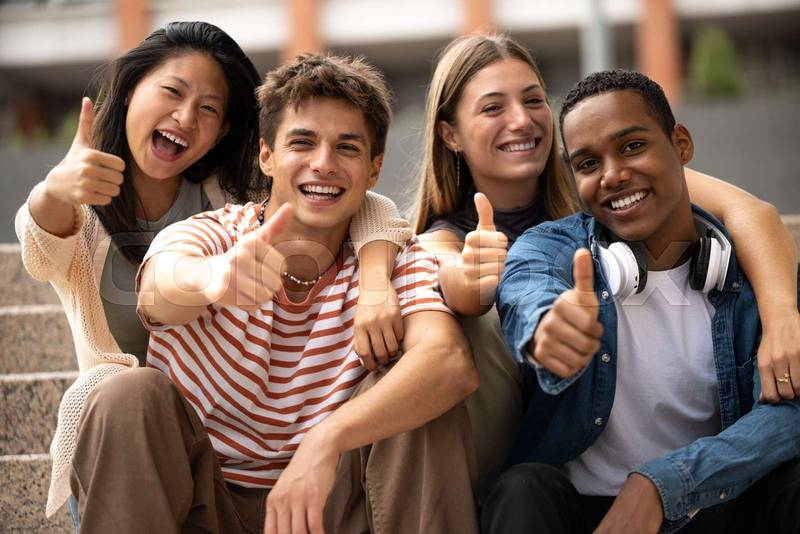 Cheerful multicultural group of friends showing thumbs up sitting on stairs. Happy young students smiling and satisfied sitting outside.