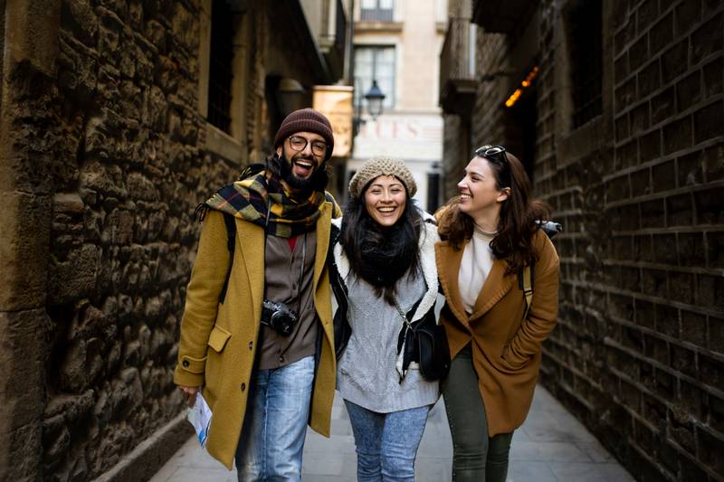 Cheerful multi-ethinc group of friends tourists having fun and walking on the streets of Barcelona - Travel, holidays and friendship concept
