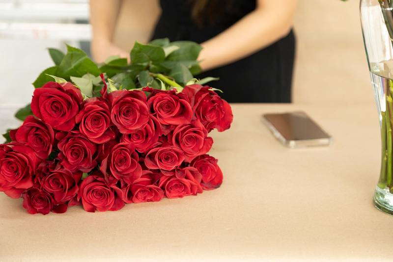putting together a bouquet of natural red roses on a table, details of petals