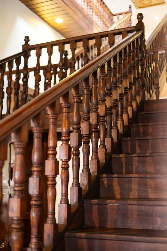 old wooden staircase inside an elegant vintage home, featuring polished wood