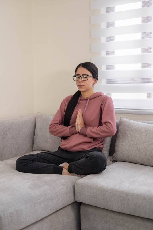 Mindful Woman Practicing Meditation at Home on Cozy Sofa