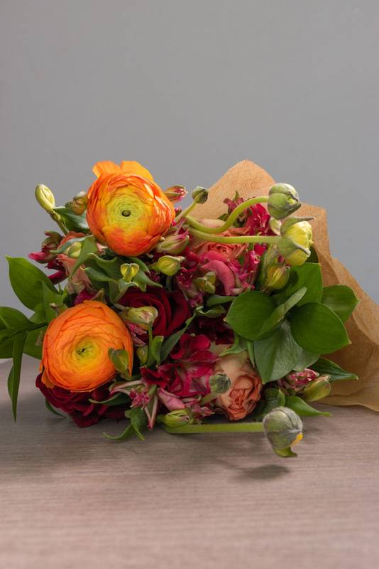 head of a bouquet with different types of flowers and leaves wrapped in decorative paper