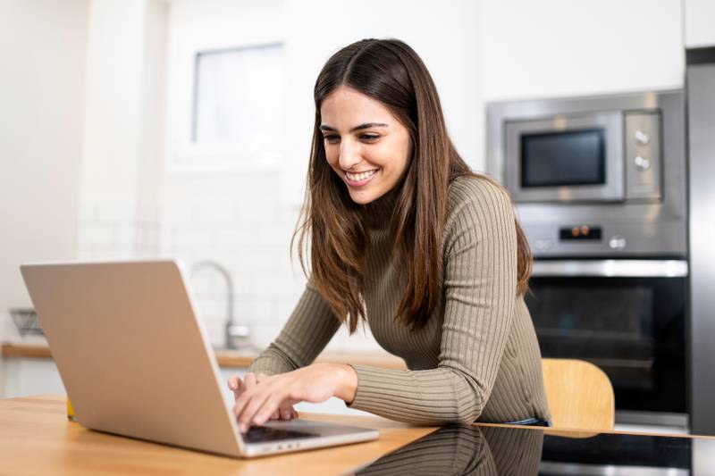 happy young attractive woman shopping online with a laptop computer using a credit card. e-commerce, business concept