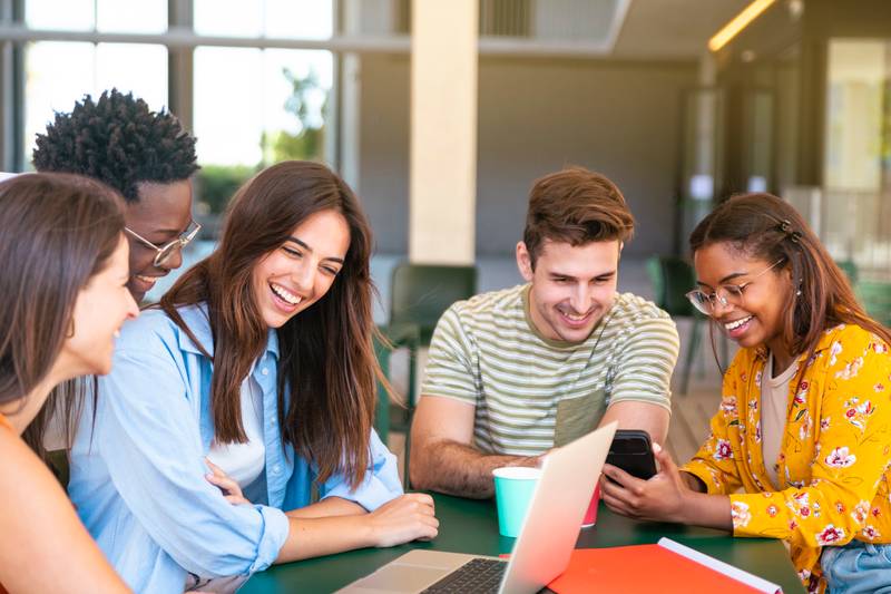Multiracial group of happy friends studying in university - Young cheerful students having fun - Positive and education concept