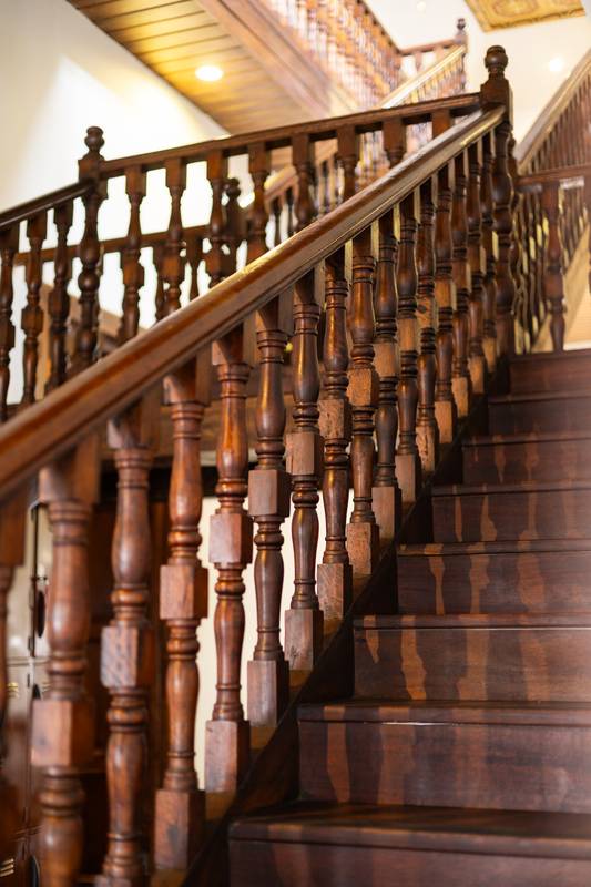 old wooden staircase inside an elegant vintage home, featuring polished wood