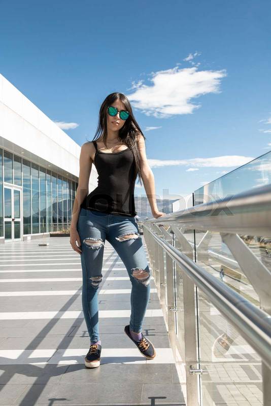 full body shot of young woman with long black hair, slim posing