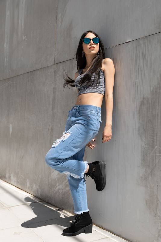 beautiful woman leaning against a wall on a sunny summer day, fashion and natural beauty