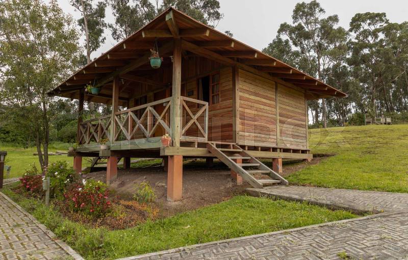 house with wooden facade with balcony and steps, rustic style with garden
