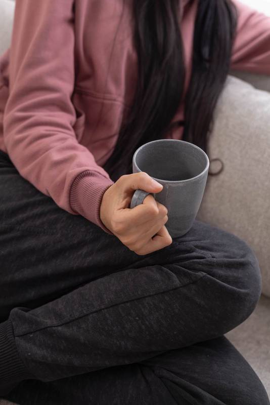 holding a cup of coffee, enjoying a peaceful moment of relaxation