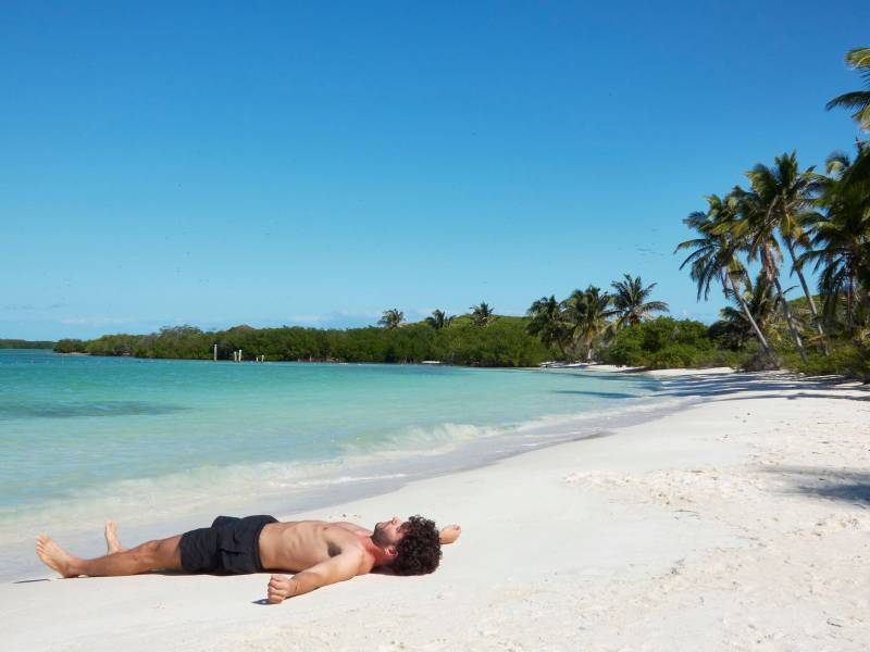 lonely man lying on a paradisiacal beach very relaxed