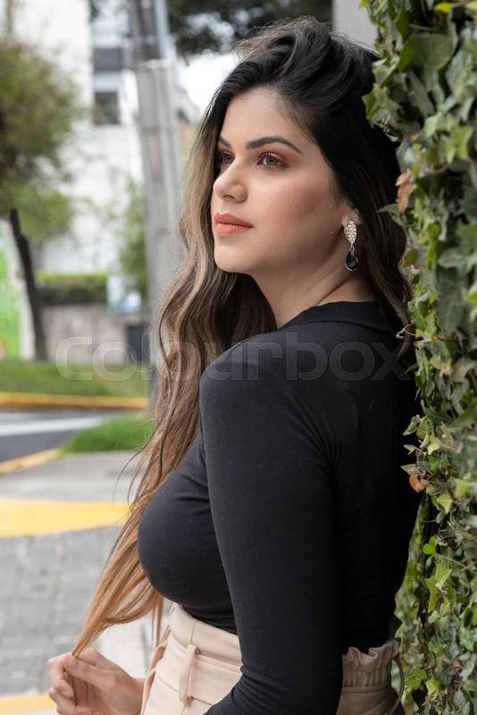 on a sidewalk, with long hair, makeup and wears a casual skirt, lifestyle  of woman