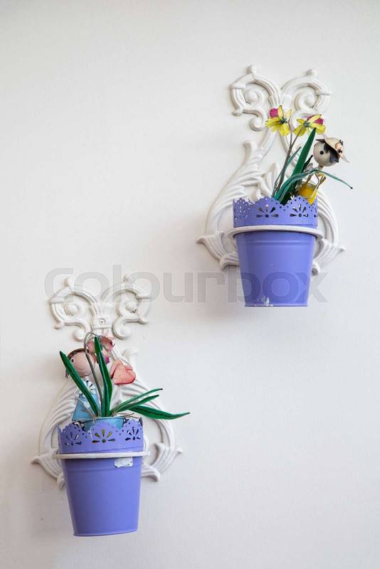 metal flower pots hanging on a white wall, colorful decorative