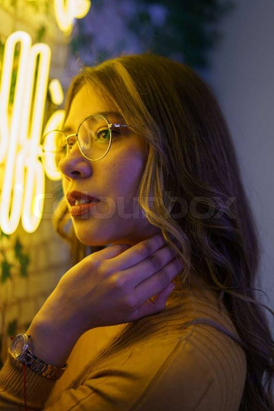 face of beautiful young latin woman with wavy hair posing with one hand on her face