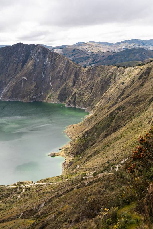 Quilotoa Lake shimmers with crystal-clear waters, surrounded by towering mountains. Its volcanic origin and dramatic beauty
