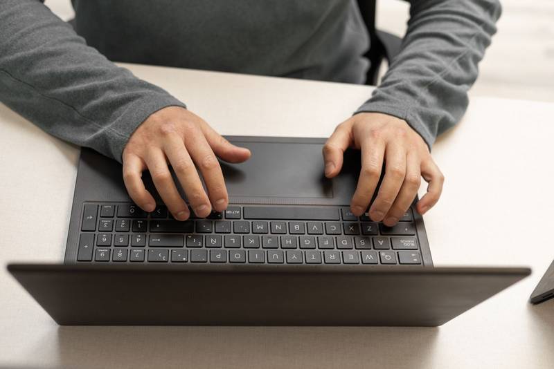 view of hands actively typing on a laptop keyboard. The image highlights concentration and productivity