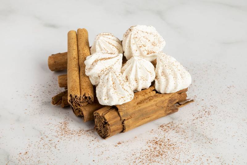 cinnamon sticks, stacked and on them some sweets, composition of kitchen ingredients