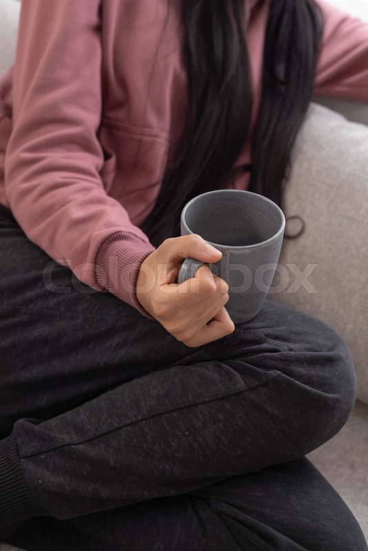 holding a cup of coffee, enjoying a peaceful moment of relaxation