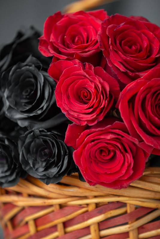 beautiful flower arrangement with black and red roses in a wicker basket, decoration