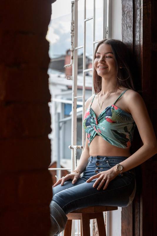 girl wearing top and jeans, and looking outside