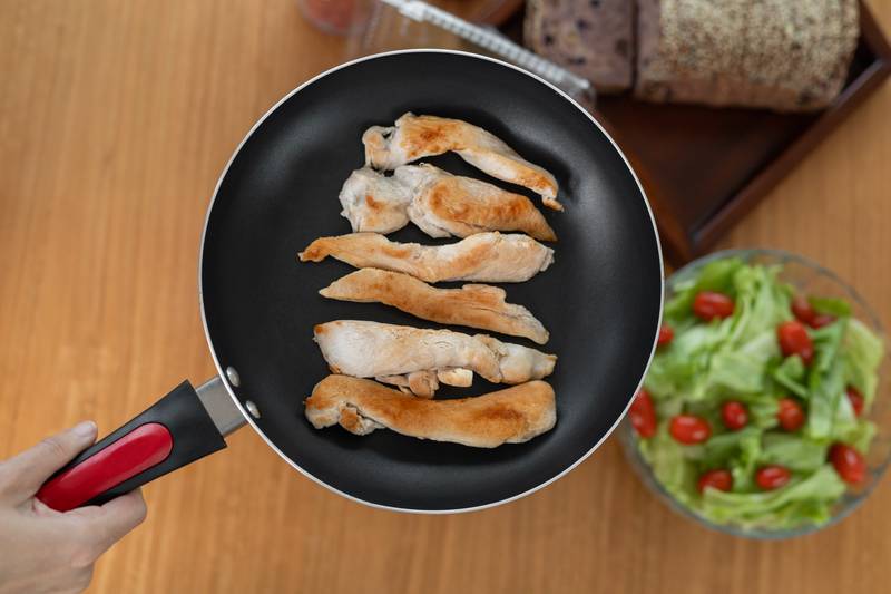 fried golden-brown chicken strips, expertly cooked to crispy perfection, paired with a fresh, vibrant tomato salad