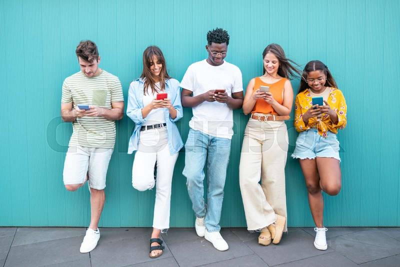 Group multiracial friends using smartphones outside