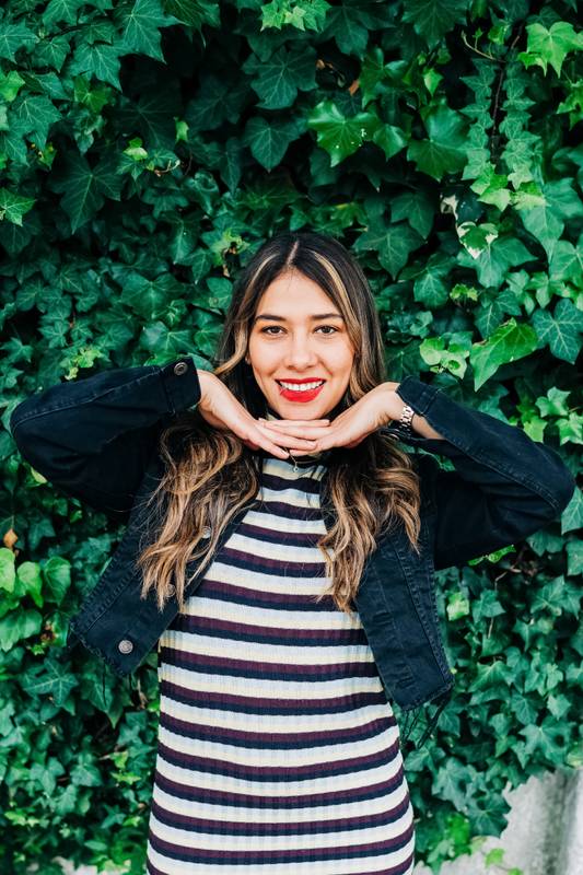 girl with long and wavy hair, beautiful makeup, posing with her hands below her face