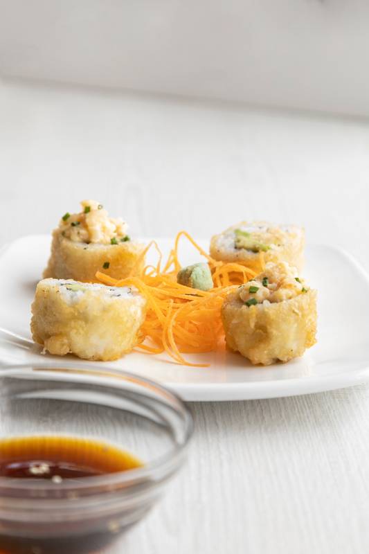 imple a plate with sushi rolls, carrot, wasabi, chopsticks and bowl with soy sauce ready to serve,