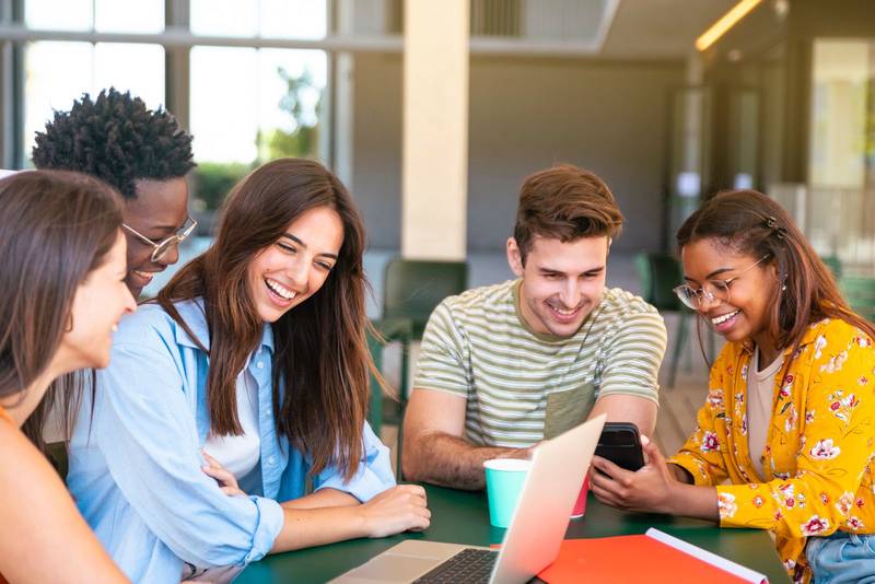 Multiracial group of happy friends studying in university - Young cheerful students having fun - Positive and education concept