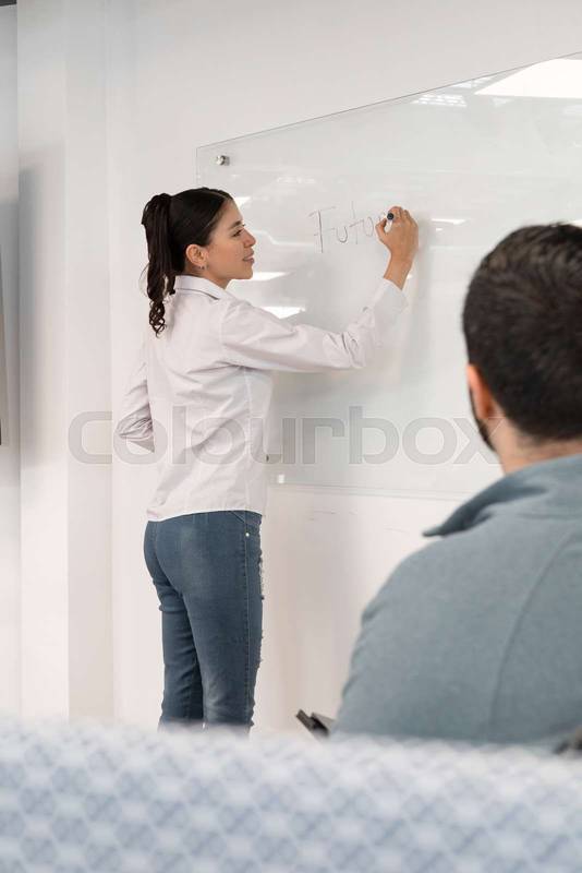 businesswoman explains the project roadmap on a whiteboard