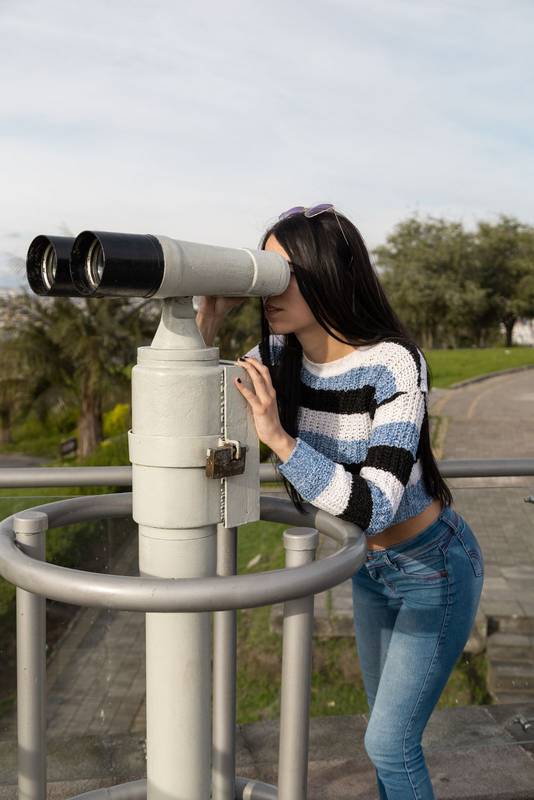 woman looking through the telescope during a city vacation