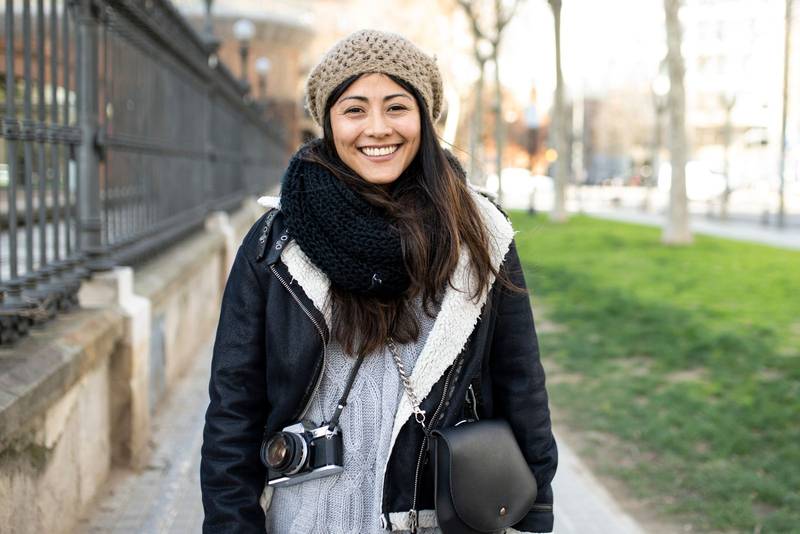 portrait of happy woman with camera in the city during her holidays. Travel, tourist concept