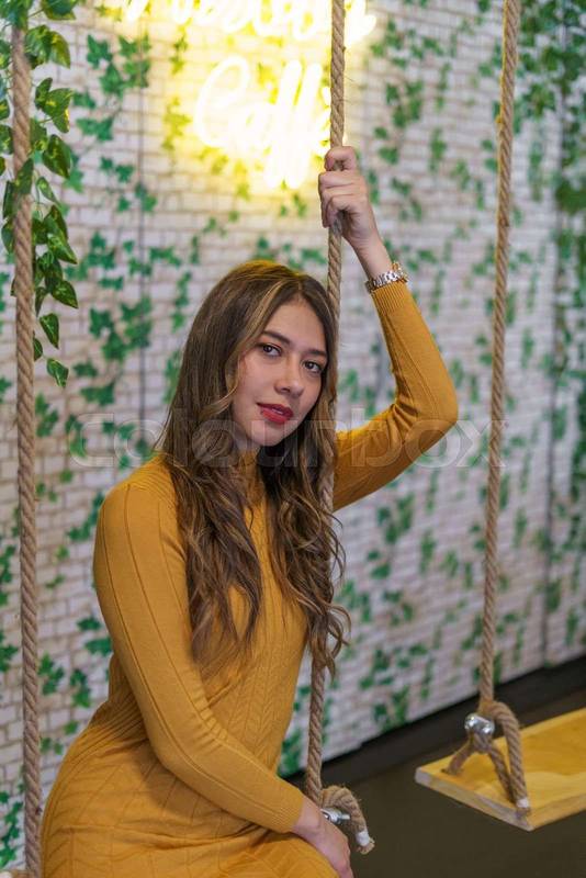 posing sitting on a swing young latin woman with blonde hair