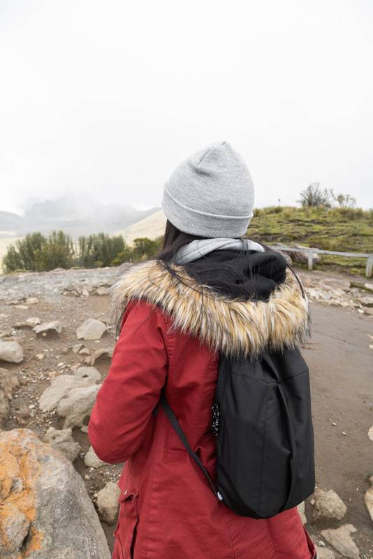 standing back a person wearing a wool cap and a jacket, tourist lifestyle in the countryside