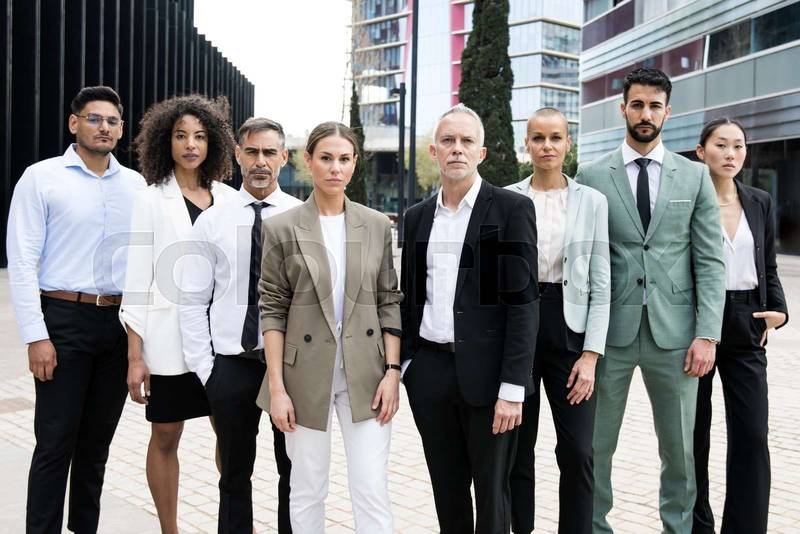 Multiethnic group of businessman and businesswoman staring at camera Multiracial confident executive team standing in the street.