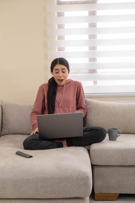 woman shouts in frustration while facing a laptop error at home. Concept of stress, anger