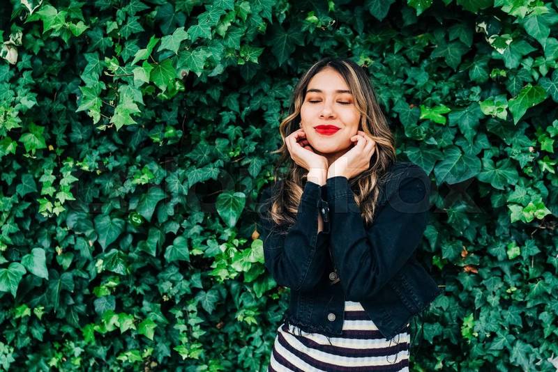 fresh leaf vine next to adorable latin young female model with long blonde hair