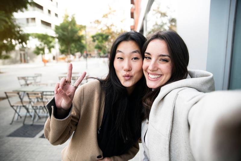 Two young friends taking selfie and having fun together Happy beautiful girls enjoying in the city.