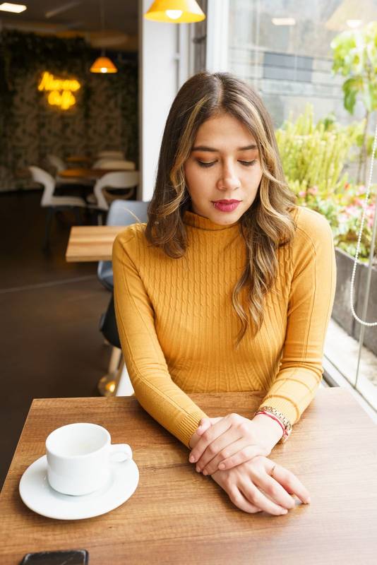 waiting sitting at a table a beautiful, young, latin woman